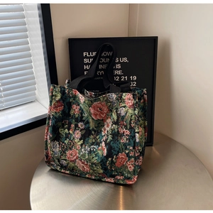 Close-up of retro floral tapestry tote bag with ethnic jacquard and black woven handles