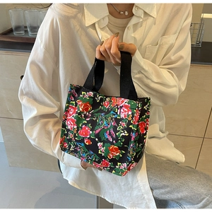 Détail d'un sac en toile à imprimé fleuri avec une fermeture à bouton-pression en métal