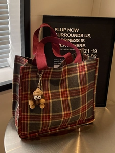 Plaid canvas tote bag in red and blue with burgundy handles and plush monster charm