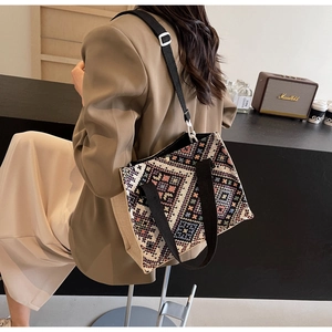 Detailed side view of an ethnic geometric woven tote bag with adjustable shoulder straps