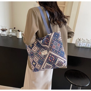 Gros plan du motif ethnique géométrique sur sac en toile avec poignée tissée bleue