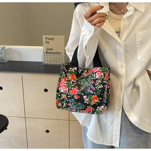 Détail du sac cabas en toile florale montrant les poignées et les motifs de fleurs