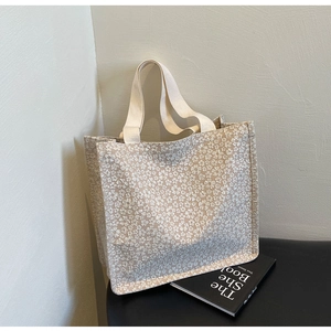 Détail du sac cabas crème avec dentelle florale texturée et anses solides en toile