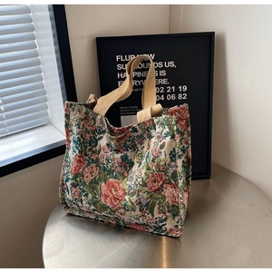 Detailed view of a vintage floral jacquard tote bag with sturdy beige canvas handles
