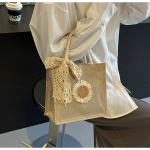 Détail d'un sac cabas en toile avec marguerite 3D et élégants rubans en dentelle