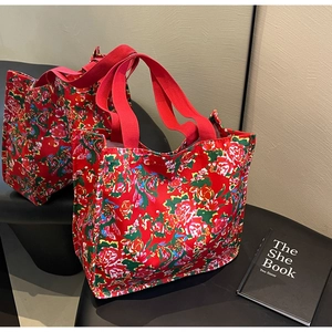 Détail de sacs fourre-tout en toile rouge avec motif traditionnel de pivoine chinoise