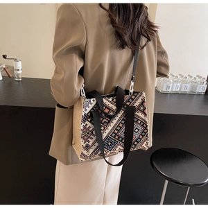 Close-up of ethnic geometric pattern tote bag with woven texture and beige linen side