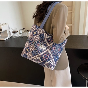 Gros plan du sac cabas en toile à motifs géométriques avec bandoulières bleues