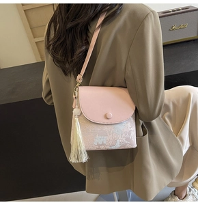 Détail du sac bandoulière rose avec motif brocart de style chinois et gland blanc élégant