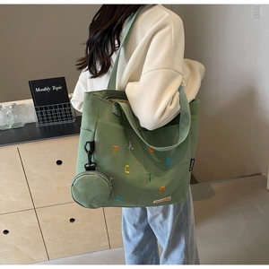 Détail du sac fourre-tout en toile verte avec broderie colorée et porte-monnaie assorti
