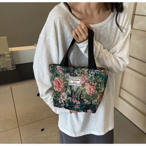 Detail of vintage jacquard tote bag featuring pink rose floral pattern and woven handles