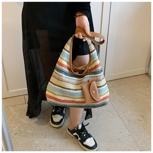 Close-up of colorful striped woven tote bag with brown leather handles and coin purse