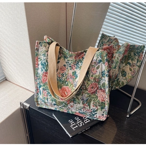 Detailed view of floral tapestry tote bag with ethnic pattern and wide beige handles