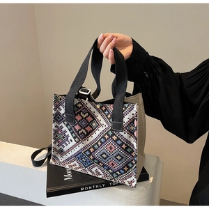 Detailed weave of geometric patterns and black straps on a versatile ethnic tote bag