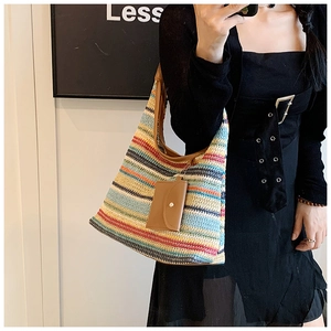 Detail view of colorful hand-woven tote bag with leather strap on model for styling