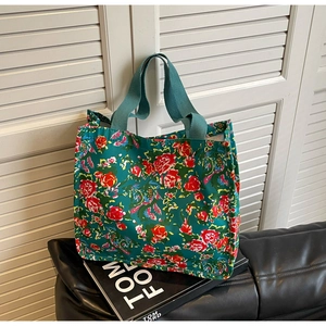 Gros plan détaillé d'un sac cabas en toile fleurie vintage avec motifs de roses rouges
