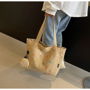 Détail du grand sac cabas en toile kaki avec lettres colorées et petit porte-monnaie