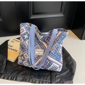 Détail du sac cabas ethnique en toile aux motifs géométriques et anses bleues tissées