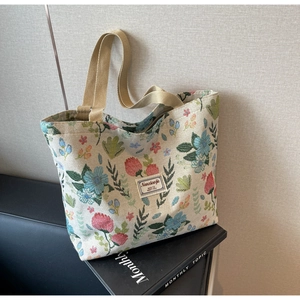 Detail of floral canvas tote bag with pink and blue flower prints and sturdy woven handles
