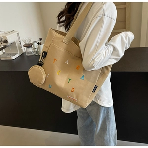 Détail du sac cabas en toile kaki avec broderies et mini porte-monnaie rond en accessoire
