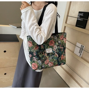 Close-up of a vintage floral jacquard canvas tote bag with a minimalist white fabric label