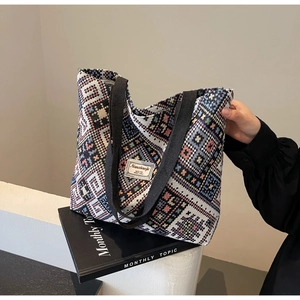 Gros plan d'un sac cabas tissé ethnique coloré avec des poignées en ruban noir durable