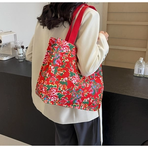 Détail d'un sac cabas en toile rouge avec des motifs floraux traditionnels chinois