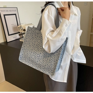 Blue floral canvas tote bag shown with a retro coffee machine in a chic urban setting