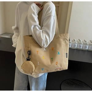 Détail du sac cabas en toile kaki avec broderie colorée et petit porte-monnaie rond