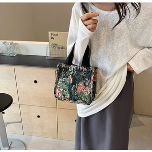 Detailed embroidery texture on a vintage floral tapestry tote bag for women