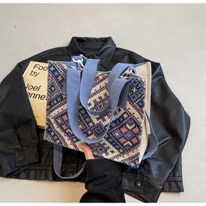 Detail of colorful geometric diamond pattern woven ethnic tote bag with blue strap