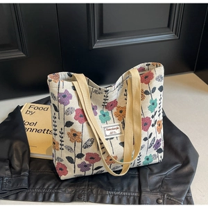 Detail of canvas tote bag showing colorful floral prints and durable stitched handles
