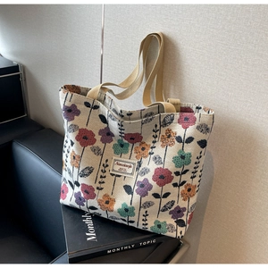 Detail of floral canvas tote bag with woven texture and vintage flower pattern