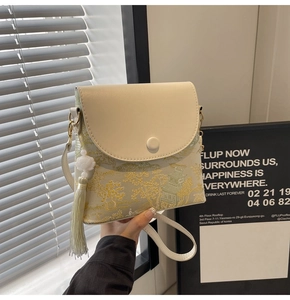 Détail de la broderie de paysage et du gland en perle de lotus sur un sac seau rétro