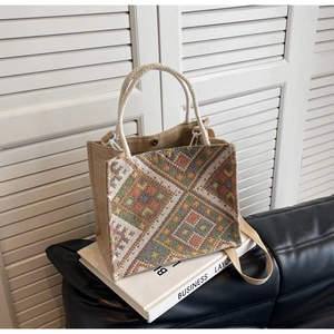 Detail of ethnic woven handbag featuring colorful geometric patterns and rope handles