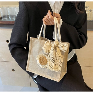 Detail of jute tote bag with 3D sunflower, lace bow, and white cotton rope handle