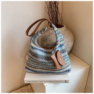 Detail of bohemian handwoven tote bag with zig-zag patterns and a small leather pouch