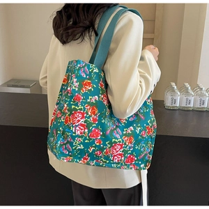 Détail du sac cabas en toile fleurie avec fleurs roses et bandoulière verte large