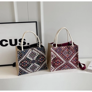 Detail of navy and burgundy ethnic tote bags featuring geometric diamond embroidery