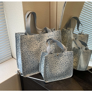 Detail of two-piece floral jacquard tote set with thick woven handles and metal clasps