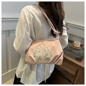 Détail d'un sac à bandoulière rose à pompons avec broderie florale chinoise typique
