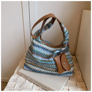 Close-up of woven tote bag texture with wavy blue patterns and brown leather handle