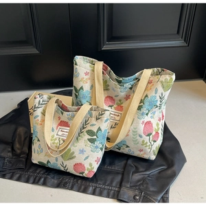 Detailed view of two floral canvas tote bags in different sizes with woven straps