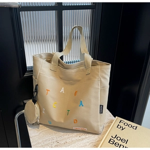 Détail du sac cabas en toile avec broderie de lettres colorées et petit porte-monnaie