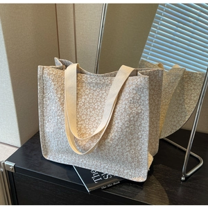 Detail of cream tote bag featuring floral jacquard texture on heavy canvas material