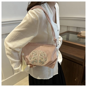 Détail du sac bandoulière rose avec broderie chinoise et pendentif à pompon en soie