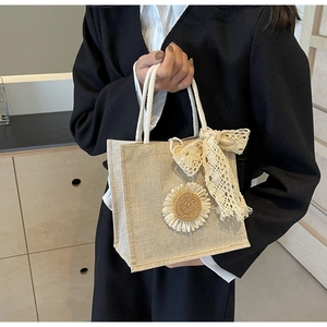 Détail du sac en toile de jute avec marguerite, nœud en dentelle et anses en corde