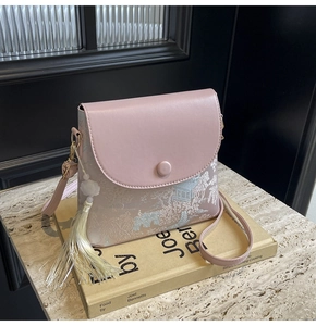 Détail du sac bandoulière rose avec broderie traditionnelle, pompon et perle de jade