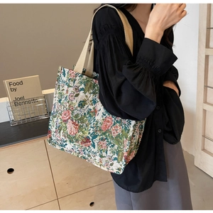 Detailed shot of ethnic tote bag featuring floral jacquard fabric and webbing handles