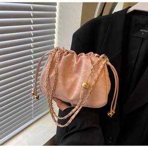 Pink pleated cloud bag detail with golden chain strap and metallic decorative balls